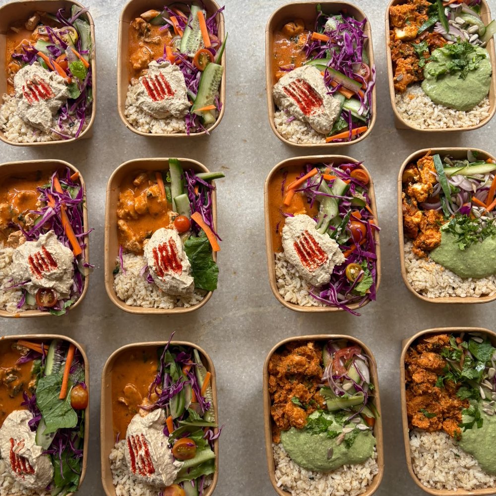 Freshly packed Protein Please meal boxes — curry, brown rice, fresh slaw and a sriracha-topped protein